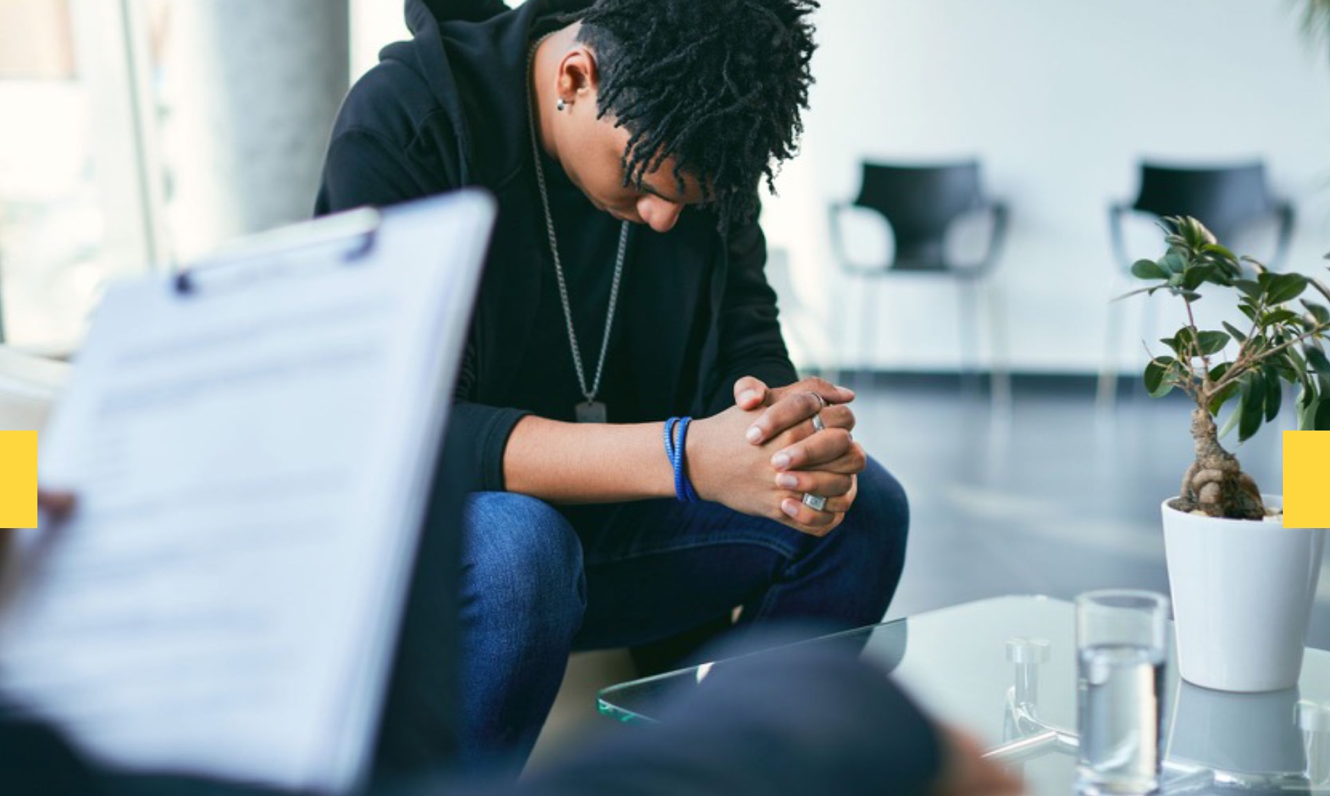 Black man sitting with his head bowed during a mental health counseling session
